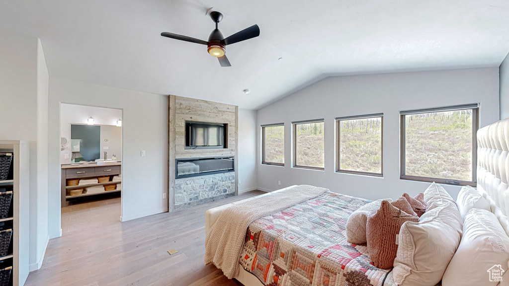 Bedroom with light wood-style flooring, lofted ceiling, and a ceiling fan