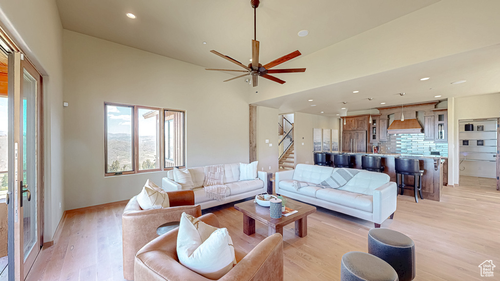 Living area with healthy amount of natural light, stairway, light wood-style flooring, ceiling fan, and recessed lighting