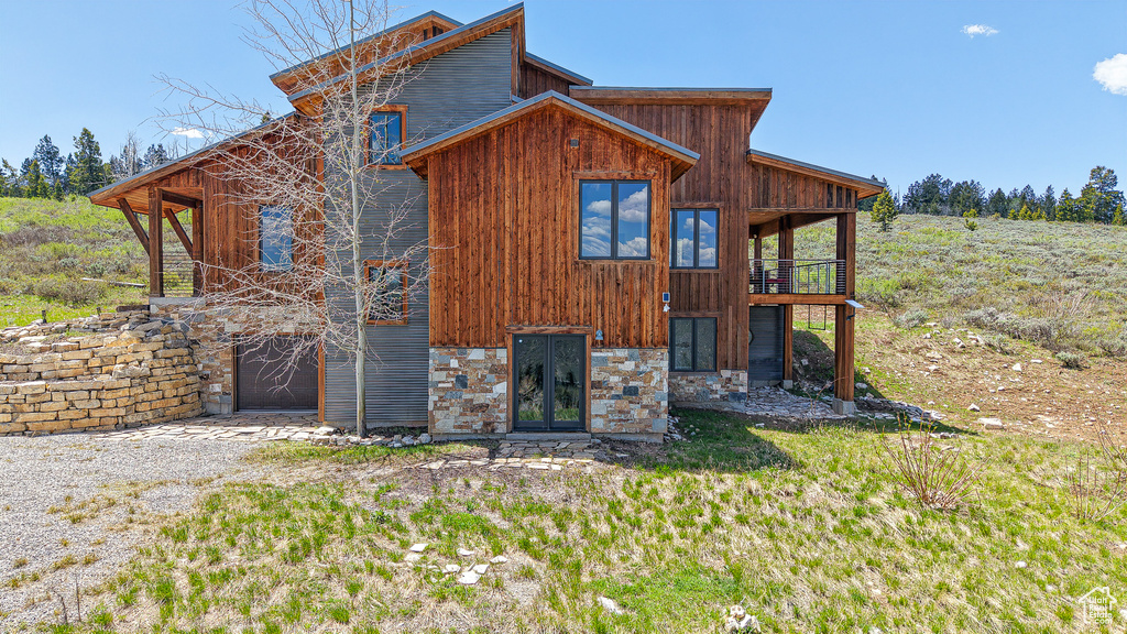 Back of house featuring stone siding