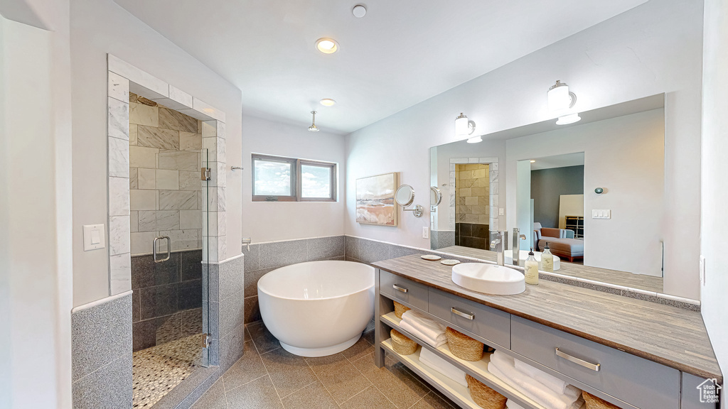 Full bathroom featuring connected bathroom, a shower stall, a freestanding bath, vanity, and recessed lighting