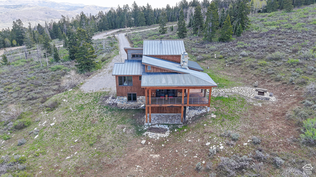 Rear view of property featuring a view of trees, metal roof, and a mountain view