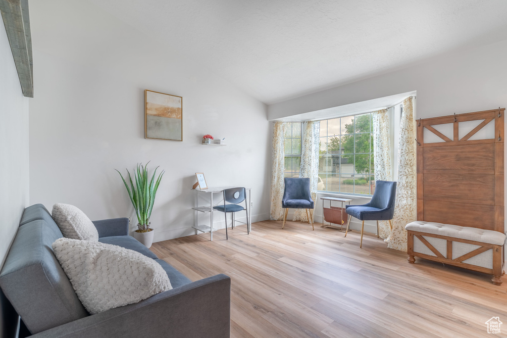 Sitting room with lofted ceiling and wood finished floors