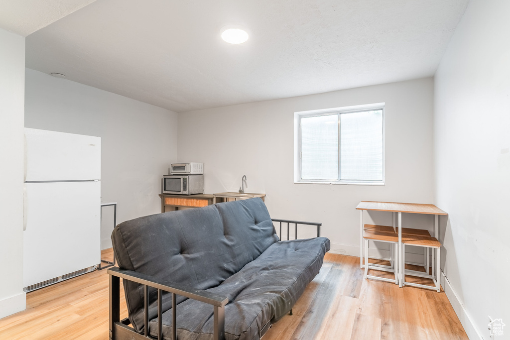 Sitting room with light wood-style floors and baseboards