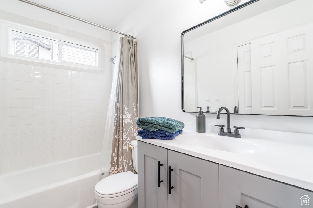 Bathroom featuring vanity, shower / tub combo, and toilet