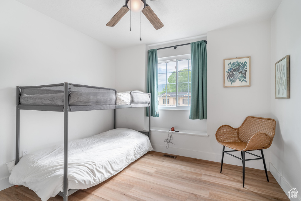Bedroom featuring wood finished floors, a ceiling fan, and baseboards
