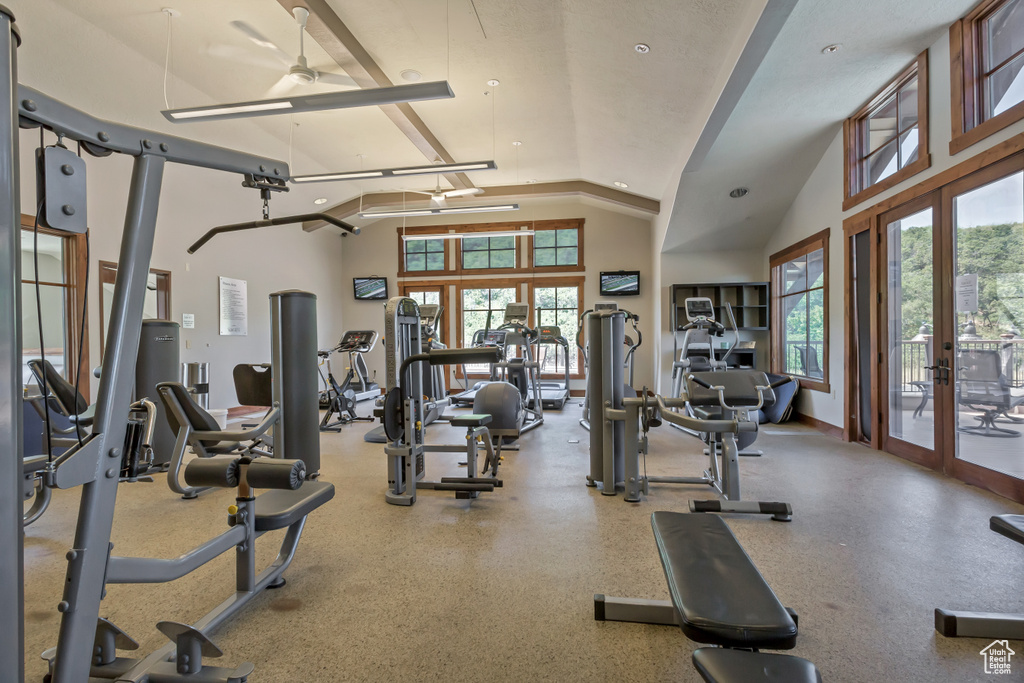 Exercise room featuring ceiling fan, vaulted ceiling, and french doors