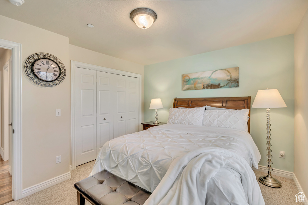 Carpeted bedroom with a closet and baseboards