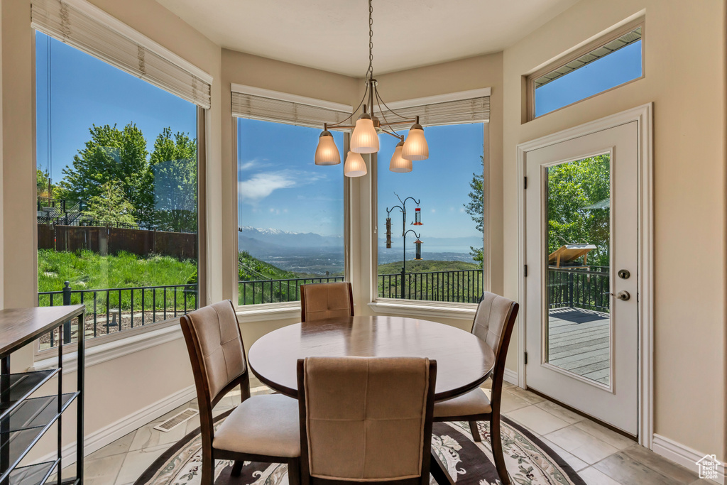 Dining room featuring healthy amount of natural light, baseboards, and a chandelier
