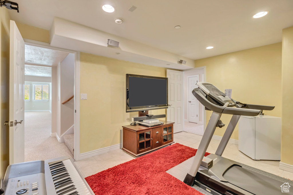 Exercise area with recessed lighting, light tile patterned floors, and baseboards
