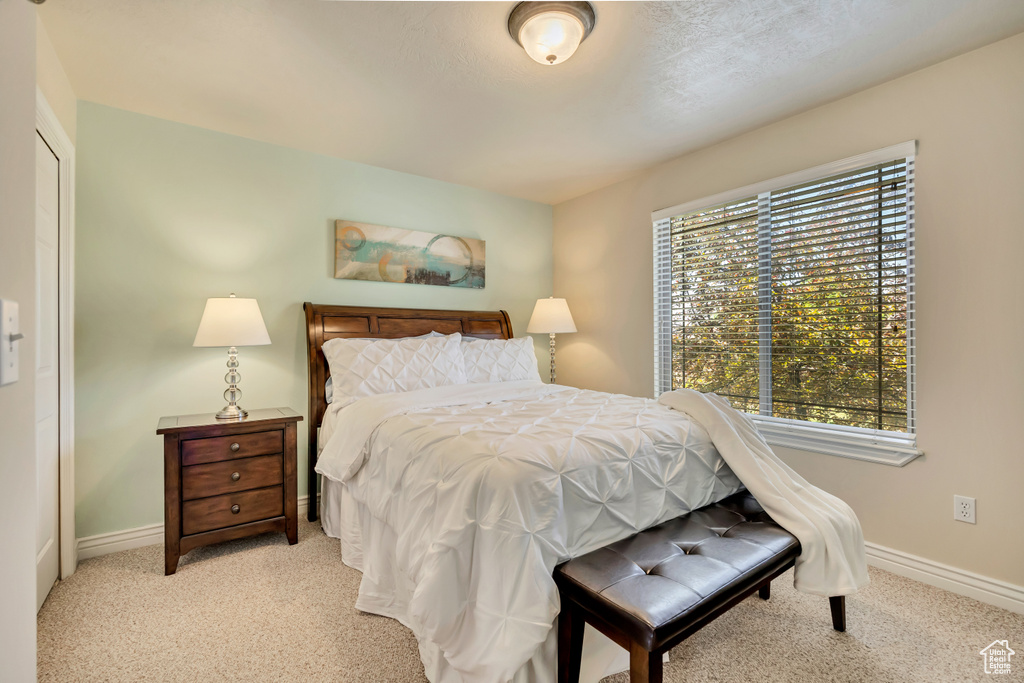 Bedroom featuring light carpet and baseboards