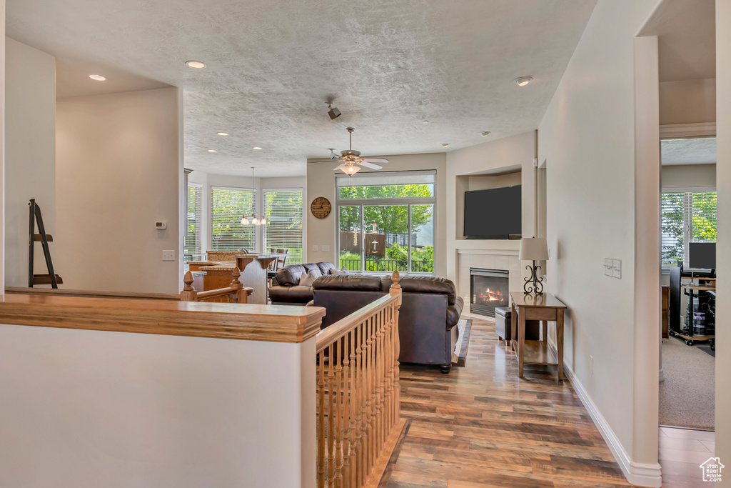 Kitchen with ceiling fan, wood finished floors, a glass covered fireplace, recessed lighting, and baseboards
