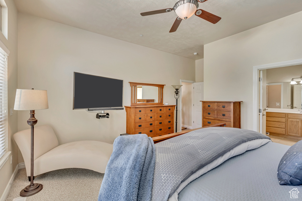 Bedroom with baseboards, ensuite bathroom, and ceiling fan