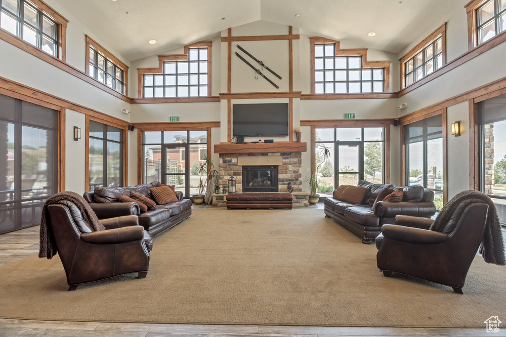 Living room with healthy amount of natural light, high vaulted ceiling, and a stone fireplace