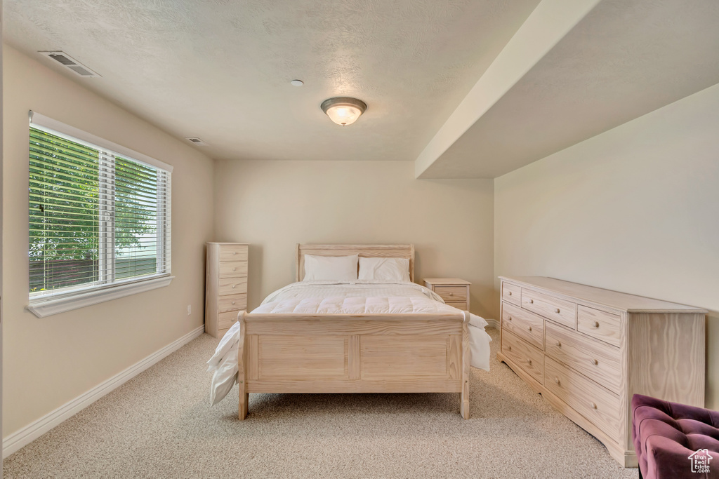 Bedroom featuring light carpet and baseboards