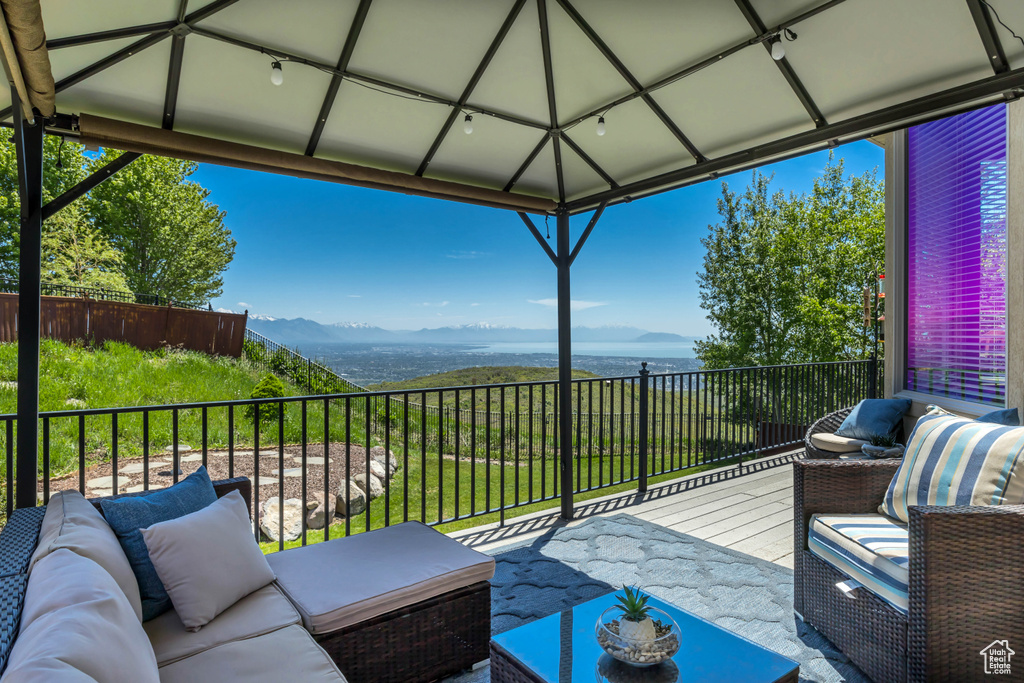 Balcony featuring outdoor lounge area, a water and mountain view, and a sunroom