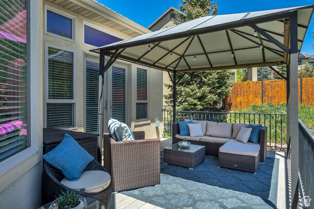 Wooden deck featuring a gazebo and outdoor lounge area