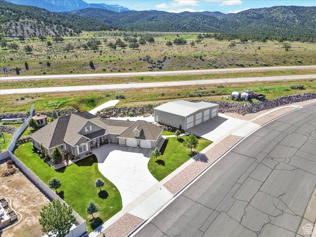 Aerial view of property and surrounding area with a mountain backdrop