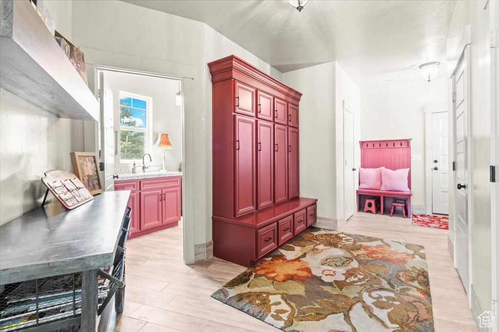 Mudroom with a sink and light wood-style floors