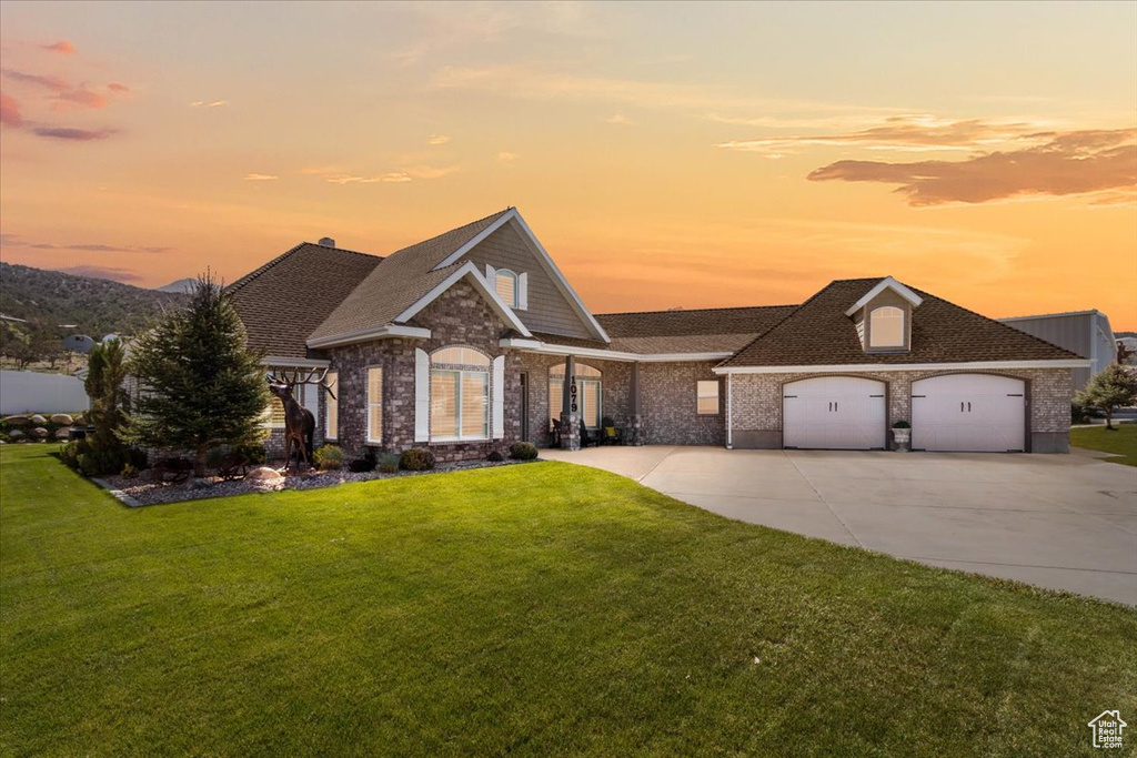 View of front of home with a front yard, concrete driveway, an attached garage, and a shingled roof