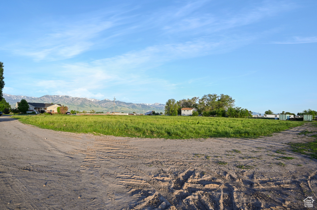 View of dirt / gravel road featuring a mountain view and a view of countryside