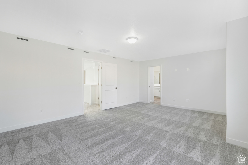 Empty room with light carpet and baseboards