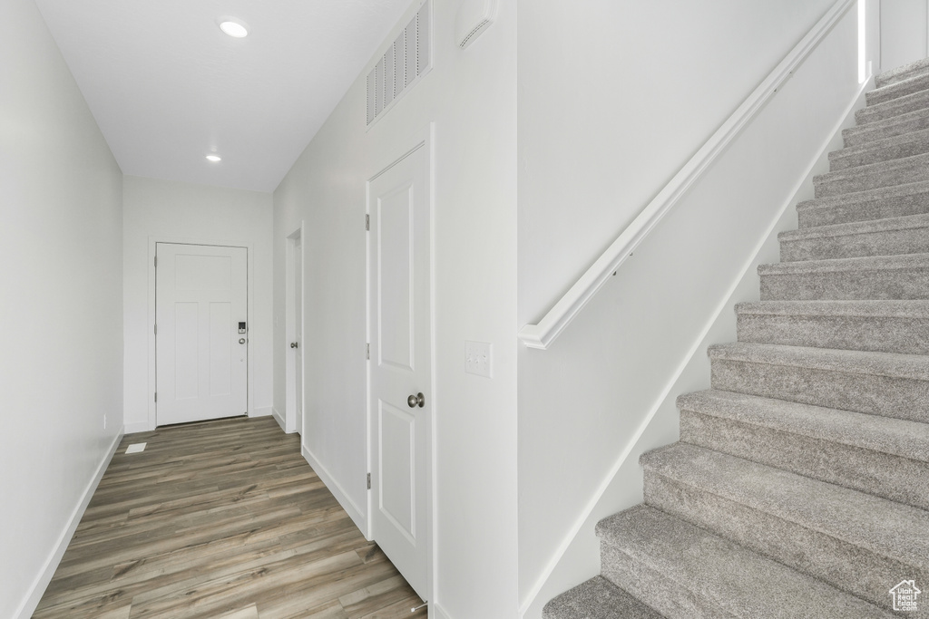 Stairs featuring wood finished floors, baseboards, and recessed lighting