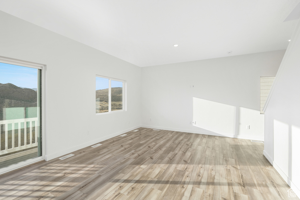 Spare room featuring light wood-style flooring and baseboards