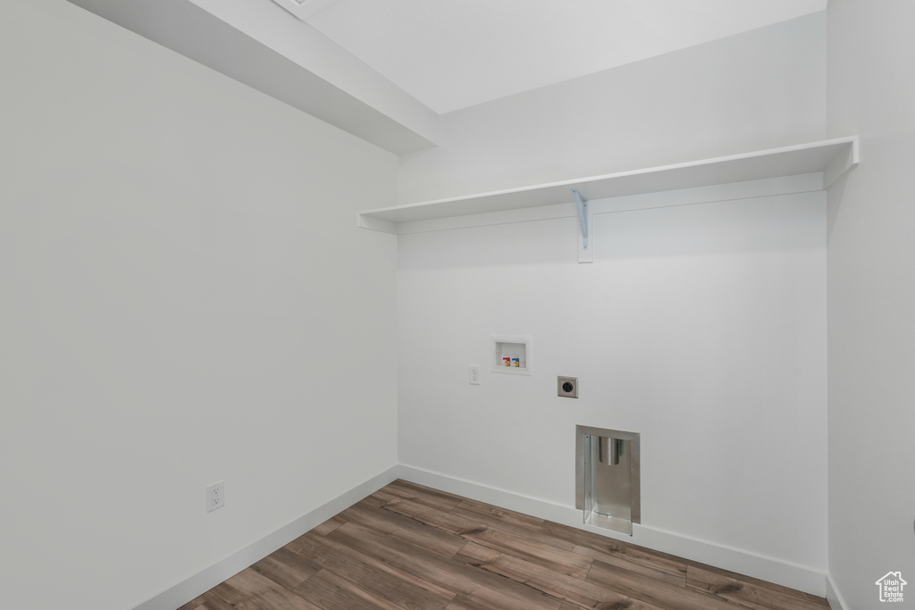 Laundry room with hookup for an electric dryer, washer hookup, wood finished floors, and baseboards