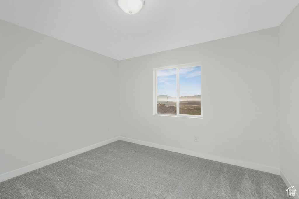 Empty room featuring carpet and baseboards