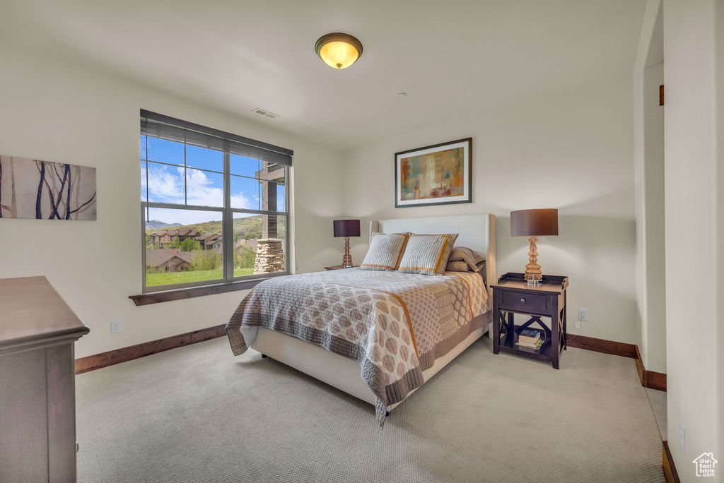 Bedroom with light carpet and baseboards