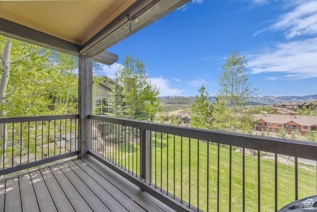 Wooden deck with a mountain view, a residential view, and a lawn