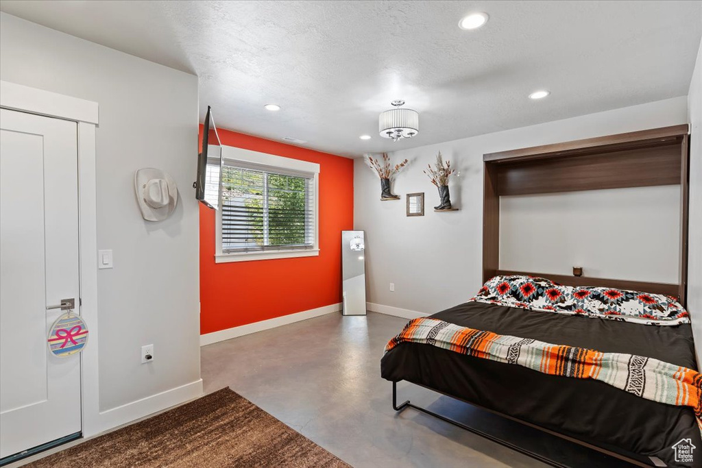 Bedroom featuring finished concrete floors, recessed lighting, and baseboards