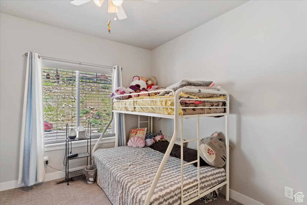 Carpeted bedroom featuring baseboards and ceiling fan
