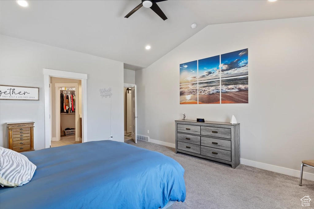 Carpeted bedroom featuring vaulted ceiling, a walk in closet, recessed lighting, baseboards, and a ceiling fan