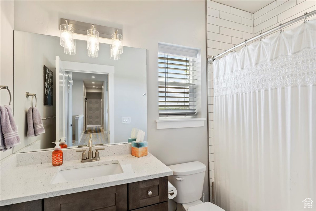 Bathroom with vanity, toilet, and a shower with curtain