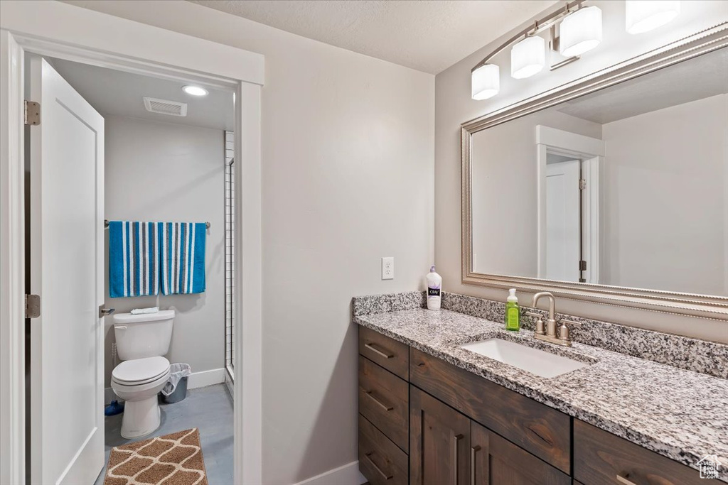 Full bath with baseboards, toilet, and vanity