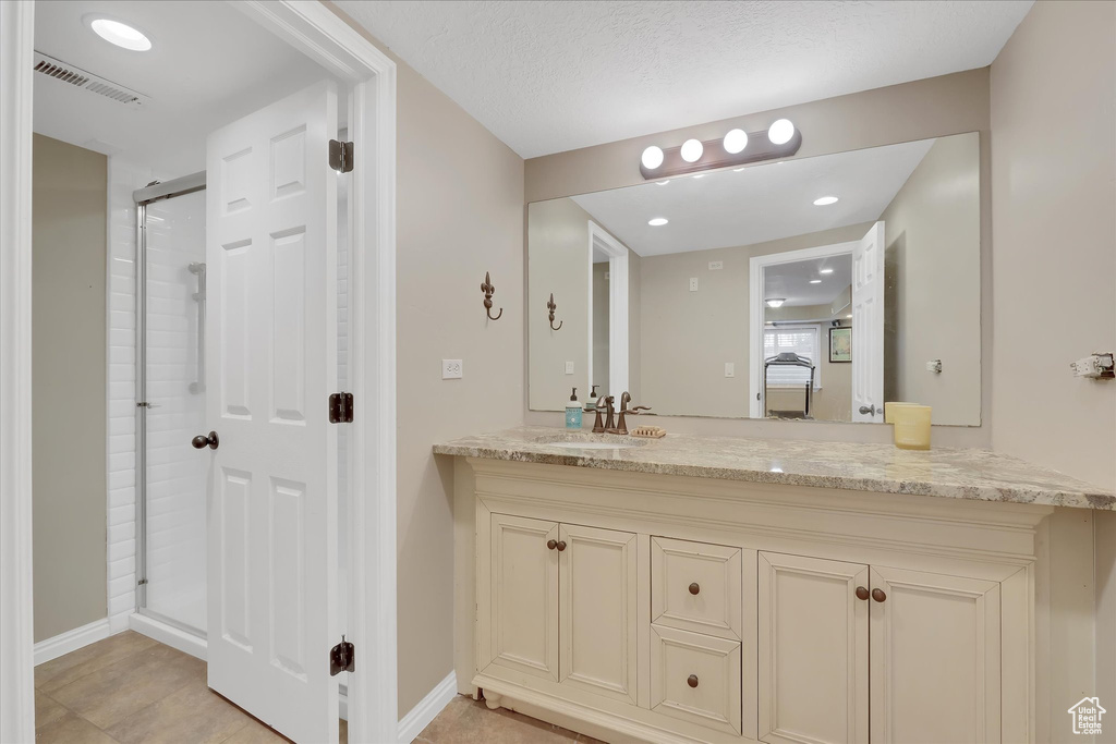 Bathroom with vanity, baseboards, an enclosed shower, and recessed lighting