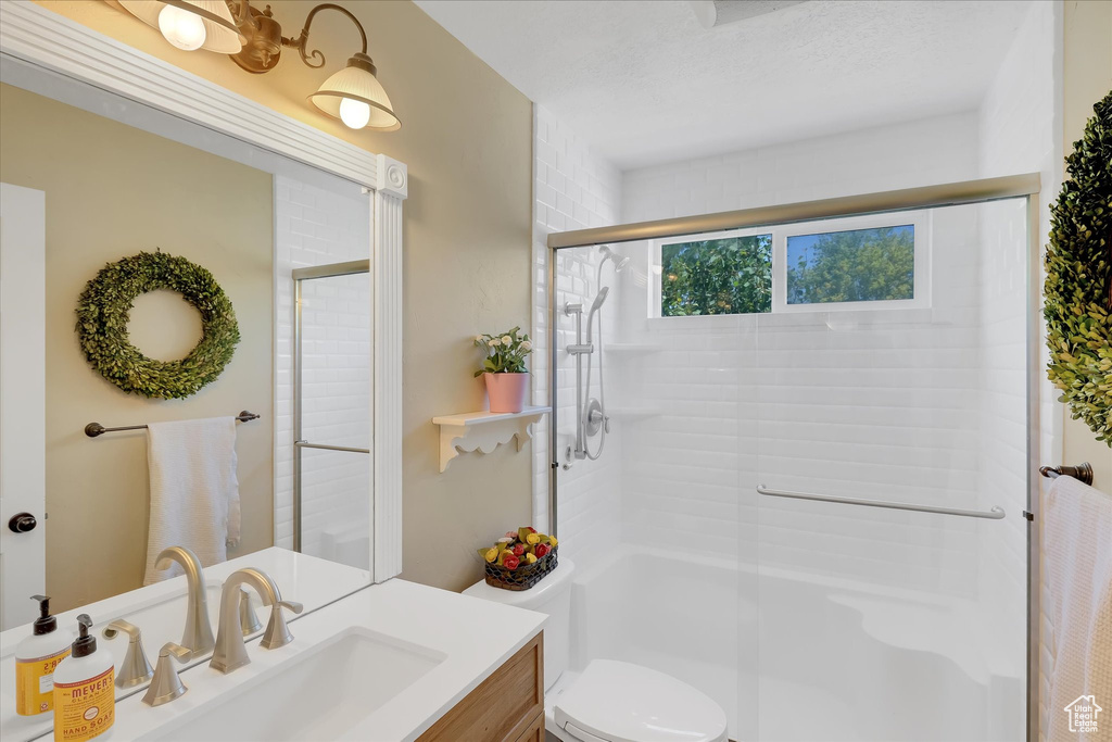 Full bathroom featuring vanity, an enclosed shower, and toilet