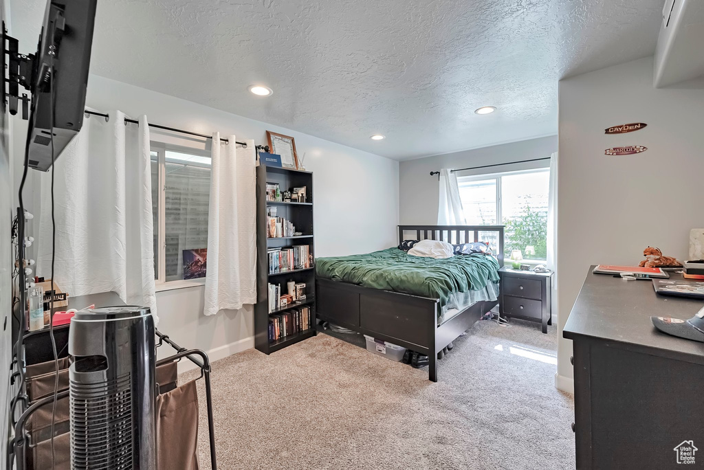 Bedroom featuring a textured ceiling, recessed lighting, carpet floors, and baseboards