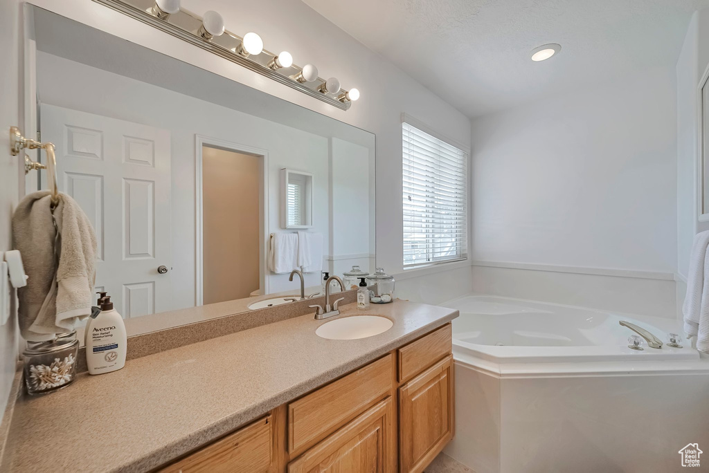 Full bathroom with vanity and a bath
