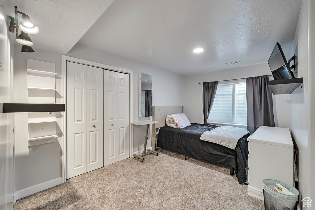 Carpeted bedroom with a closet and a textured ceiling