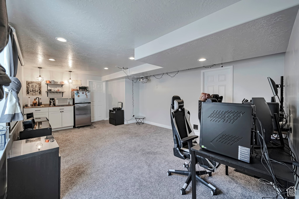 Office area featuring a textured ceiling, recessed lighting, light carpet, and baseboards