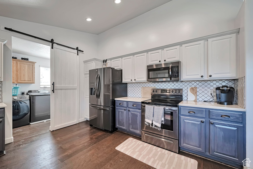 Kitchen with stainless steel appliances, light countertops, dark wood-style floors, blue cabinets, and recessed lighting