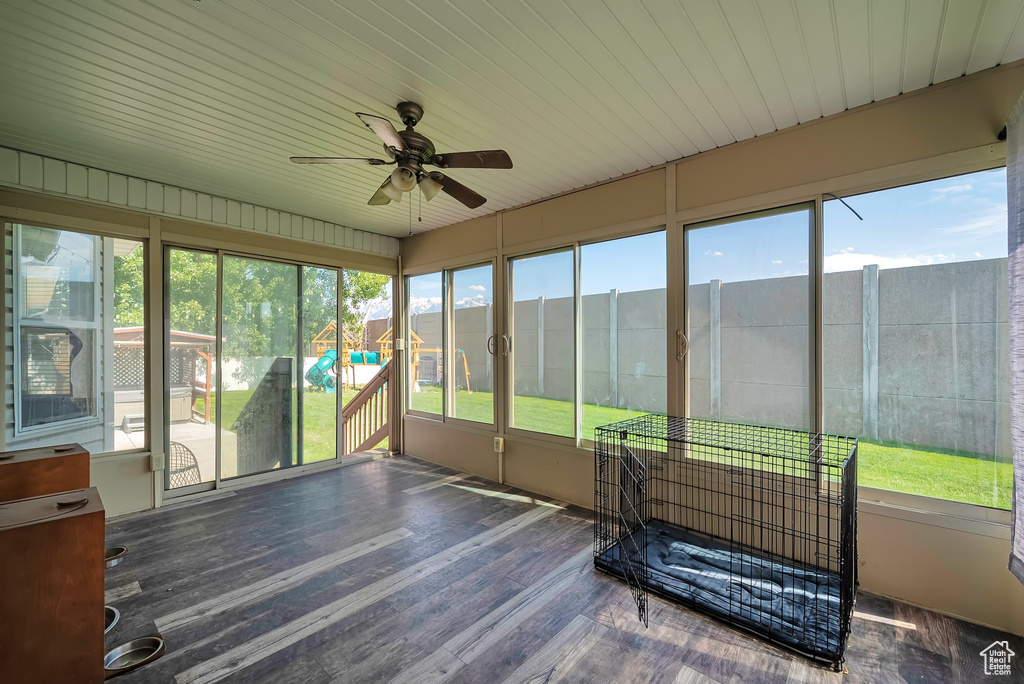 Unfurnished sunroom featuring ceiling fan and plenty of natural light