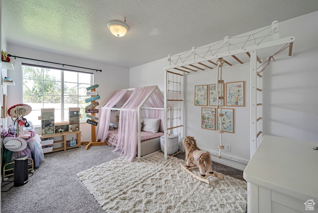 Bedroom featuring carpet floors and a textured ceiling