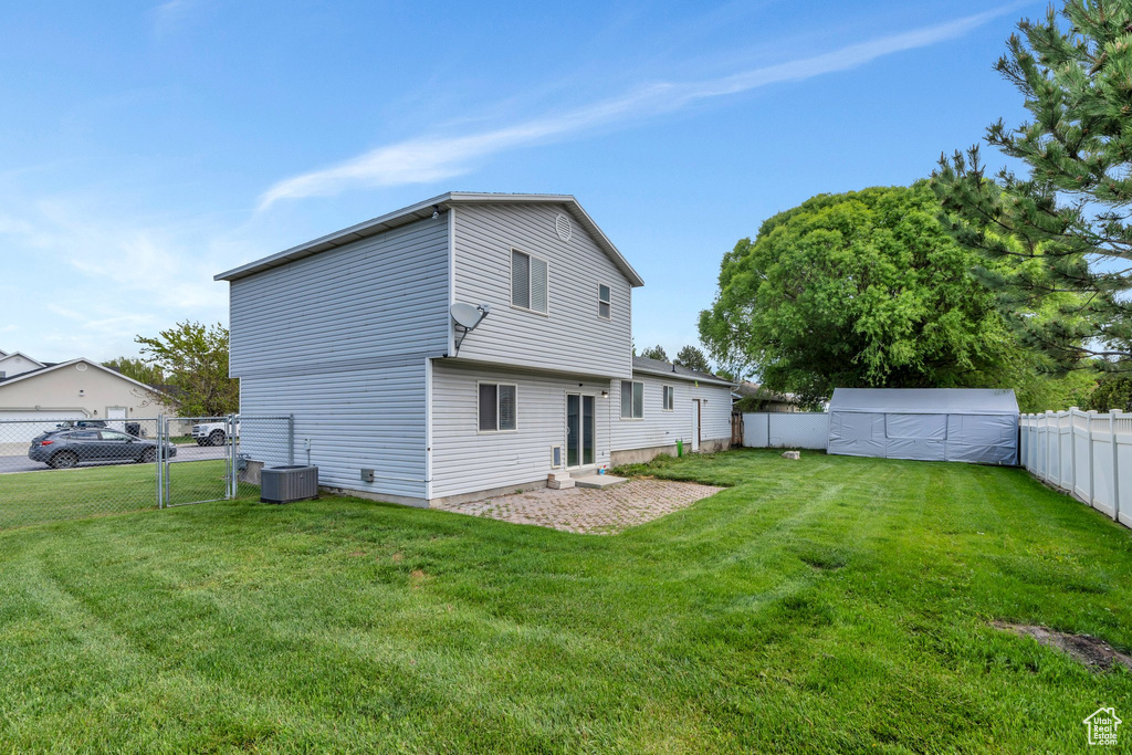 Rear view of property with a gate and central AC unit