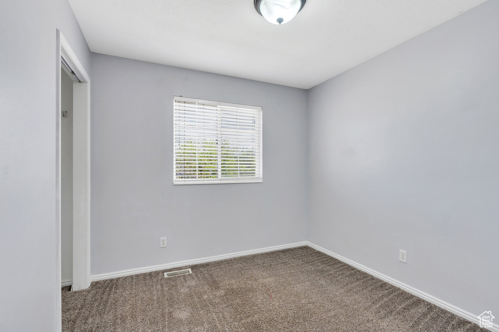 Empty room with carpet floors and baseboards