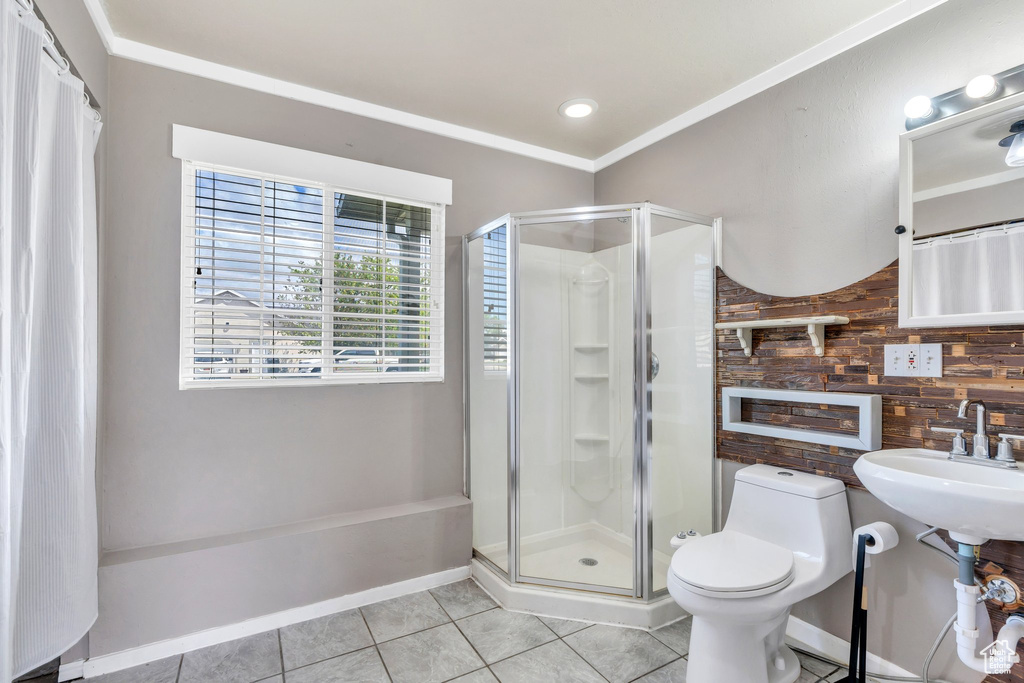 Full bathroom with tile patterned floors, a stall shower, wooden walls, and toilet