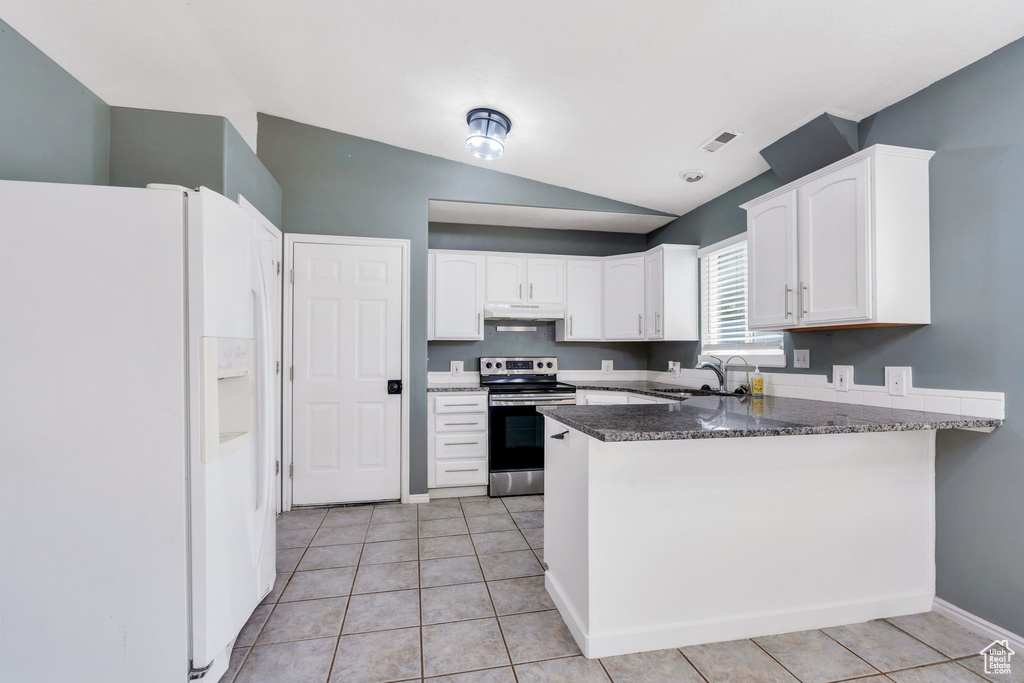 Kitchen featuring white refrigerator with ice dispenser, stainless steel electric range, under cabinet range hood, a peninsula, and lofted ceiling