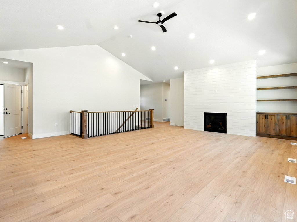 Unfurnished living room featuring ceiling fan, light wood-type flooring, lofted ceiling, recessed lighting, and baseboards